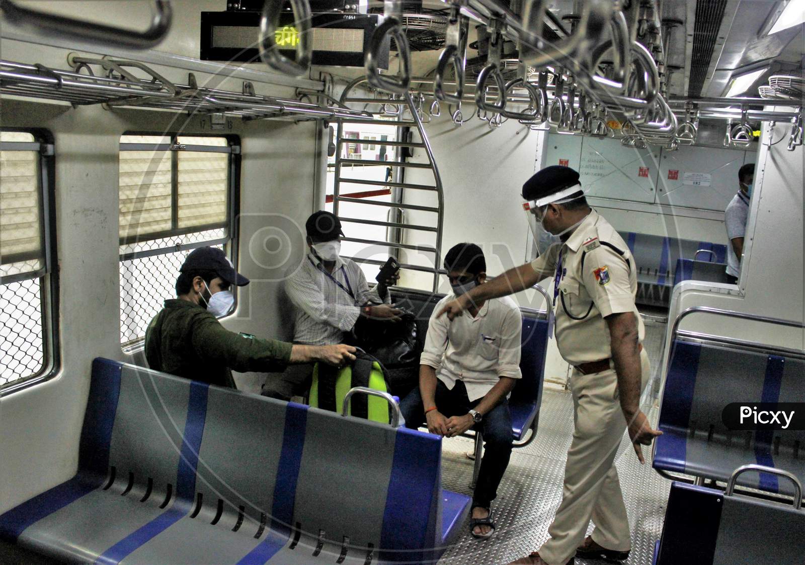 Police personnel instruct the commuters to maintain social distance inside the train, after the government eased a nationwide lockdown that was imposed as a preventive measure against the COVID-19 coronavirus, at Churchgate station, in Mumbai, India, on June 16, 2020.
