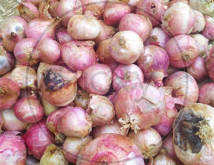 fresh pink onions as a background. In a marketplace