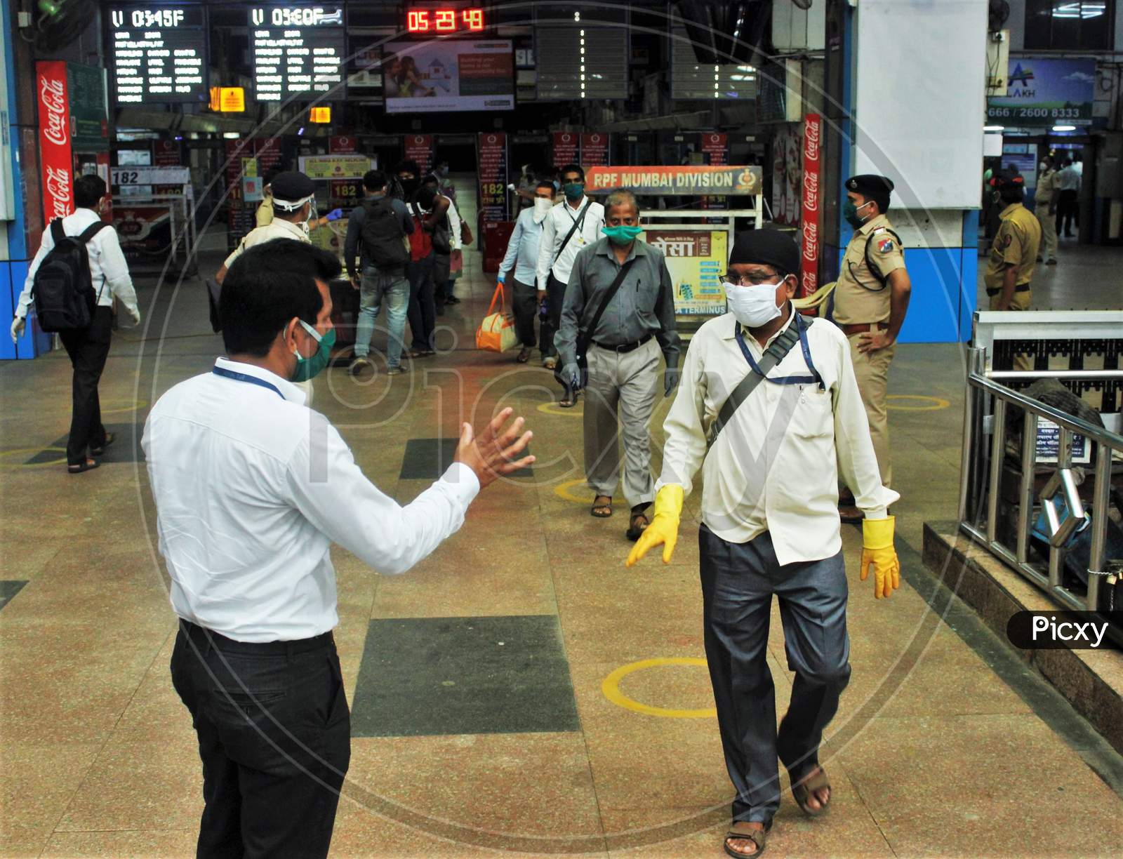 A railway official asks the commuters to show their ID cards before they board the trains, at Churchgate station, after the government eased a nationwide lockdown that was imposed as a preventive measure against the COVID-19 coronavirus, at Churchgate station, in Mumbai, India, on June 16, 2020.