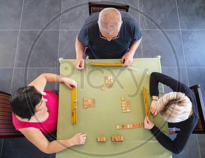 Family Of Three Playing Rummy Game Indoors