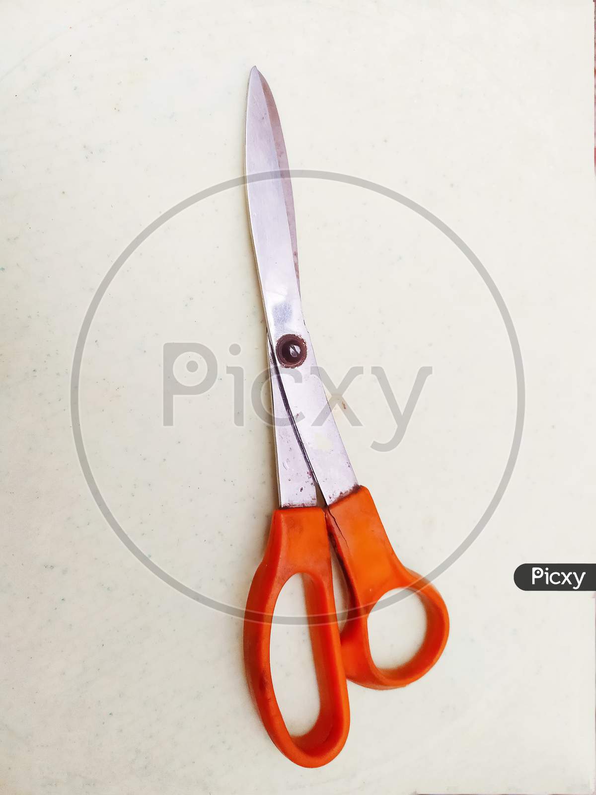 Topview of orange scissor isolated on white surface, the scissors use for tailoring uses