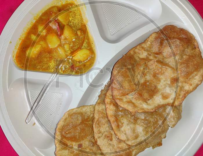 Puri and Potato Curry aalu sabji in plate Close-up- an indian cuisine in round plate.
