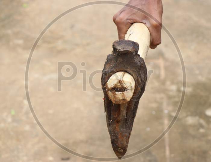 Old And Rusty Axe Which Is Mainly Used To Break Wood Held In Hand With Wooden Handle