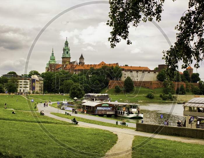 Landscape Of A Wawel Castle Next To Vistula River Against Dramatic Cloud Located In Krakow City Center In Poland, Europe