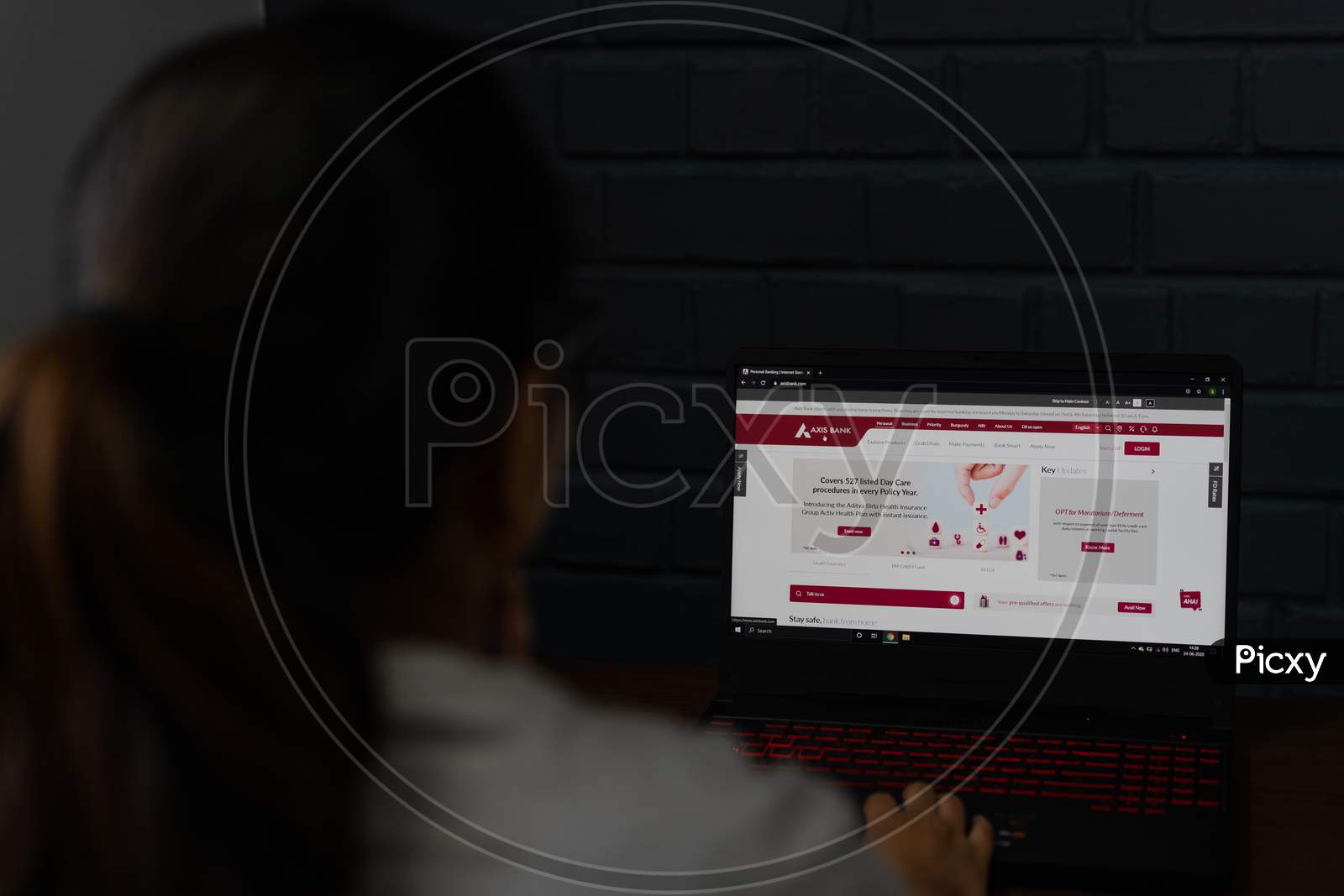 Woman checking Axis Bank home page on a laptop screen. Online banking service benefits from home