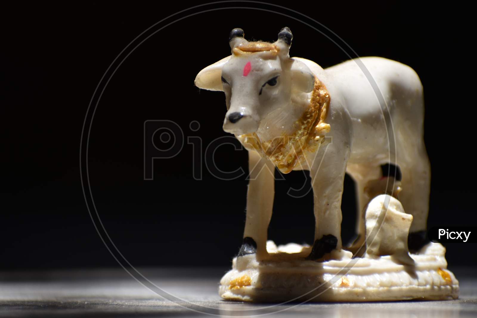 An idol of cow feeding to young one