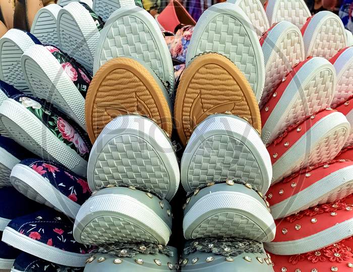 Closeup Of Many Trendy Canvas Footwear For Ladies Kept In A Tray On The Street In A Market.