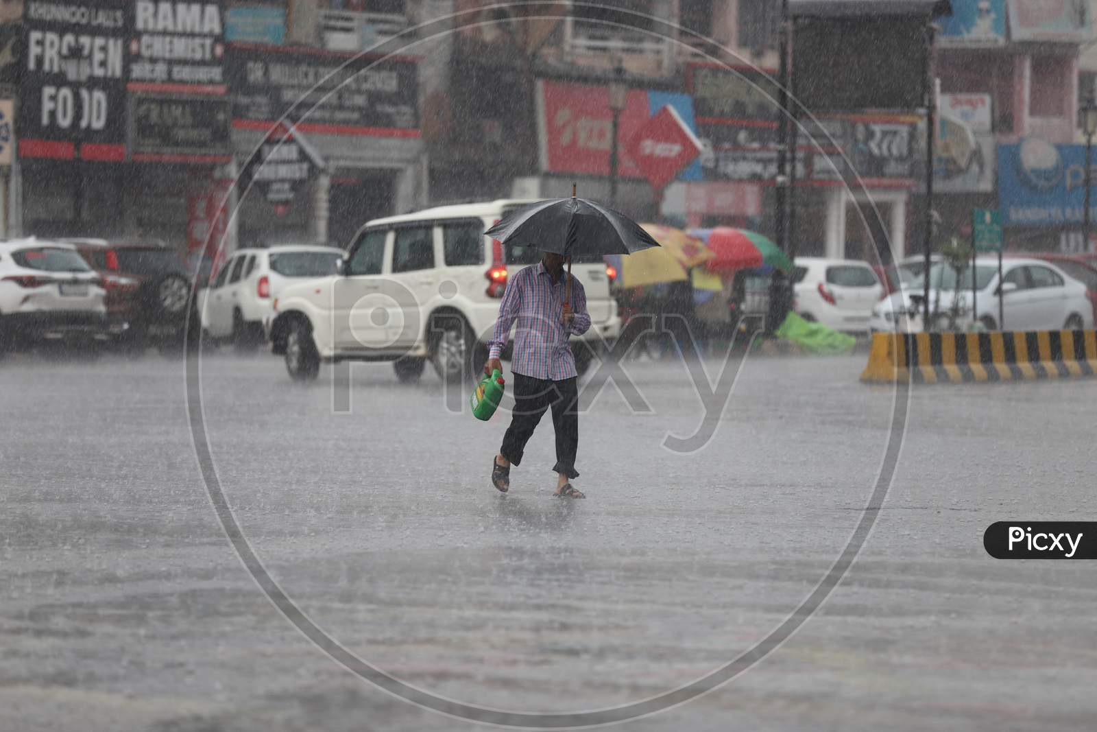 A Man Hold Umbrella as he Walks On The Road During Heavy Monsoon Rain In Prayagraj, June 25, 2020.