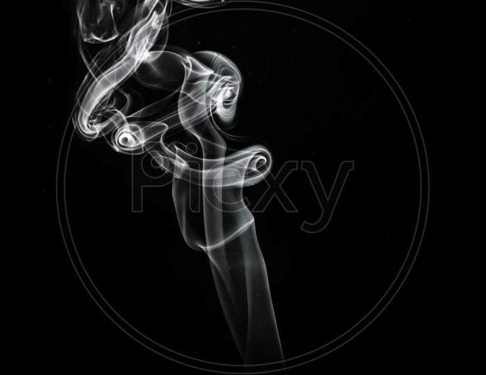 White Puffed Smoke In A Dark Background