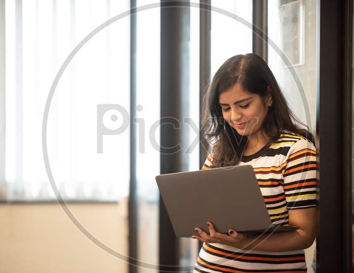Smiling young Indian girl working in an Office.