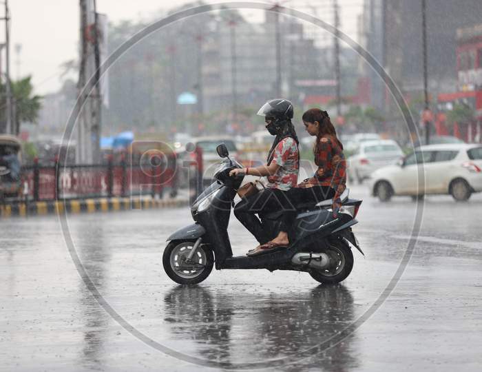 Girls Ride a Scooty On The Road During Heavy Monsoon Rain In Prayagraj, June 25, 2020.