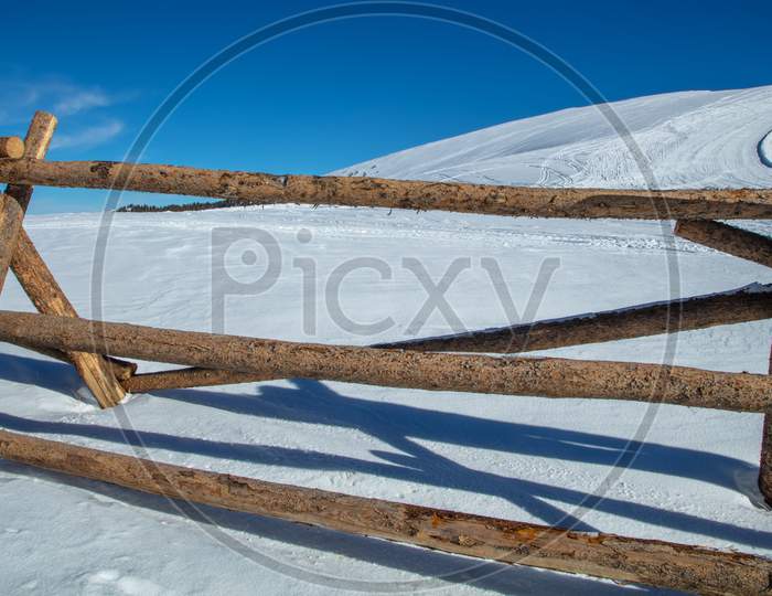 Large Wooden Fence On Snow Covered Mountain