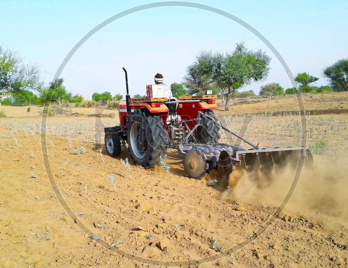 A Tractor Working In A Field Agriculture Activities