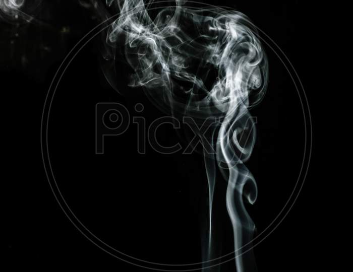 White Puffed Smoke In A Dark Background