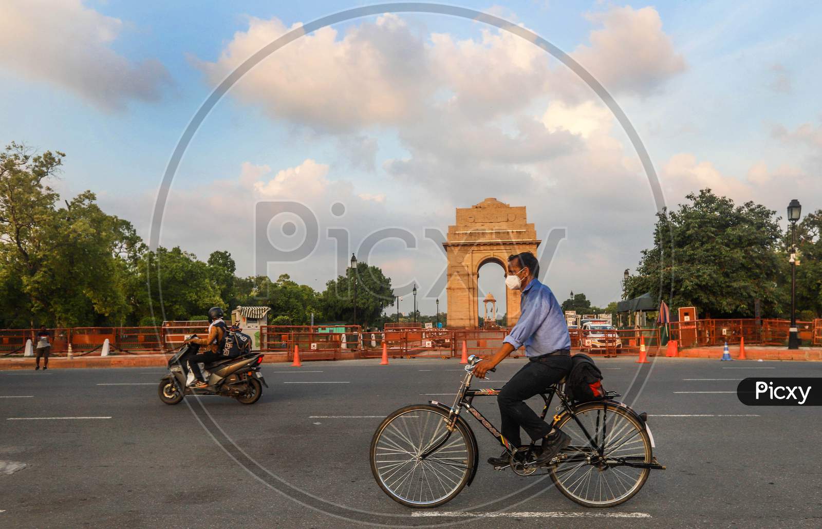 A cyclist wearing a face mask as he pedals in front of India Gate, in New Delhi, India.