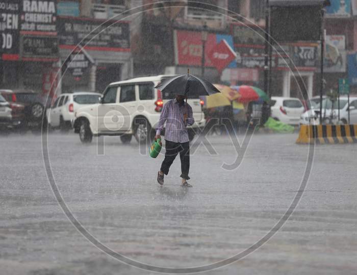 A Man Hold Umbrella as he Walks On The Road During Heavy Monsoon Rain In Prayagraj, June 25, 2020.