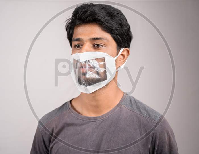 Young Man With Transparent Medical Face Mask, To Help Hearing Imperimeant Or Deaf People To Understand Lipreading During Coronavirus Or Covid-19 Outbreak