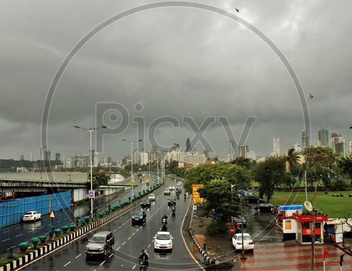 A general view shows dark clouds lingering over the city's skyline at Marine Drive during heavy rains, in Mumbai, India on June 18, 2020.