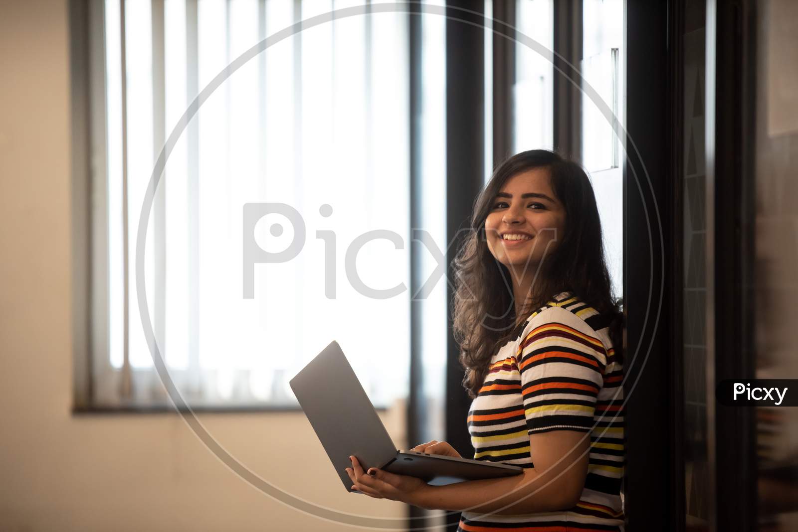 Smiling young Indian girl working in an Office.