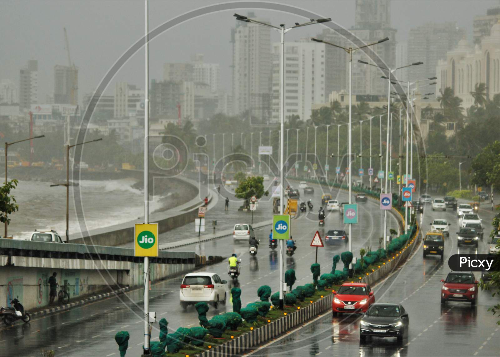 Cars and bikes are seen on a road at Marine Drive during rains, in Mumbai on June 18, 2020.
