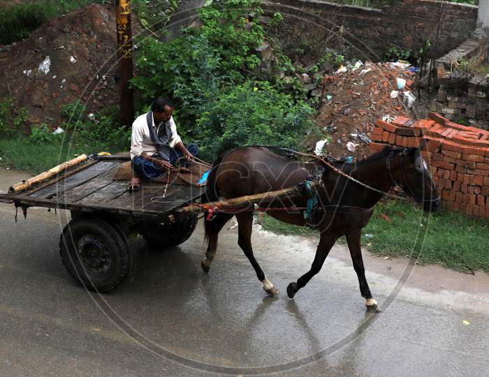 A man rides a horse cart during rains in Prayagraj, June 26, 2020.
