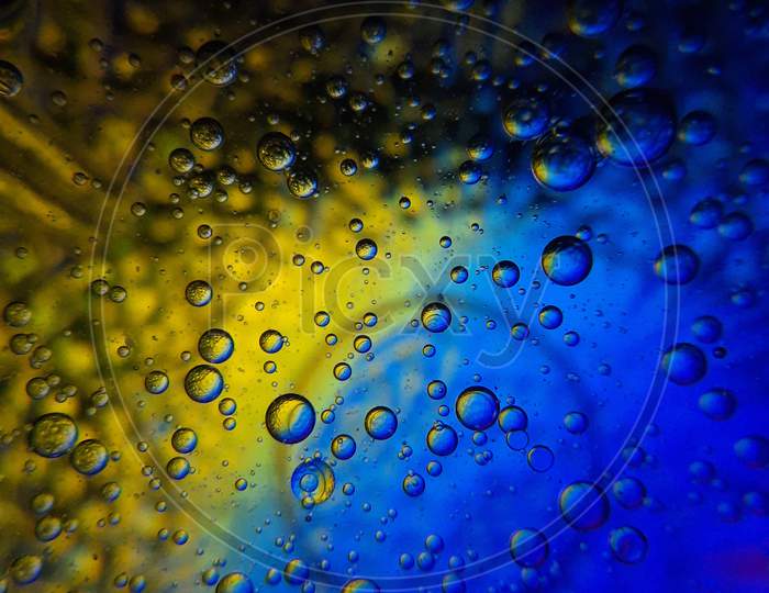 Macro shots of oil bubble mixed in water.