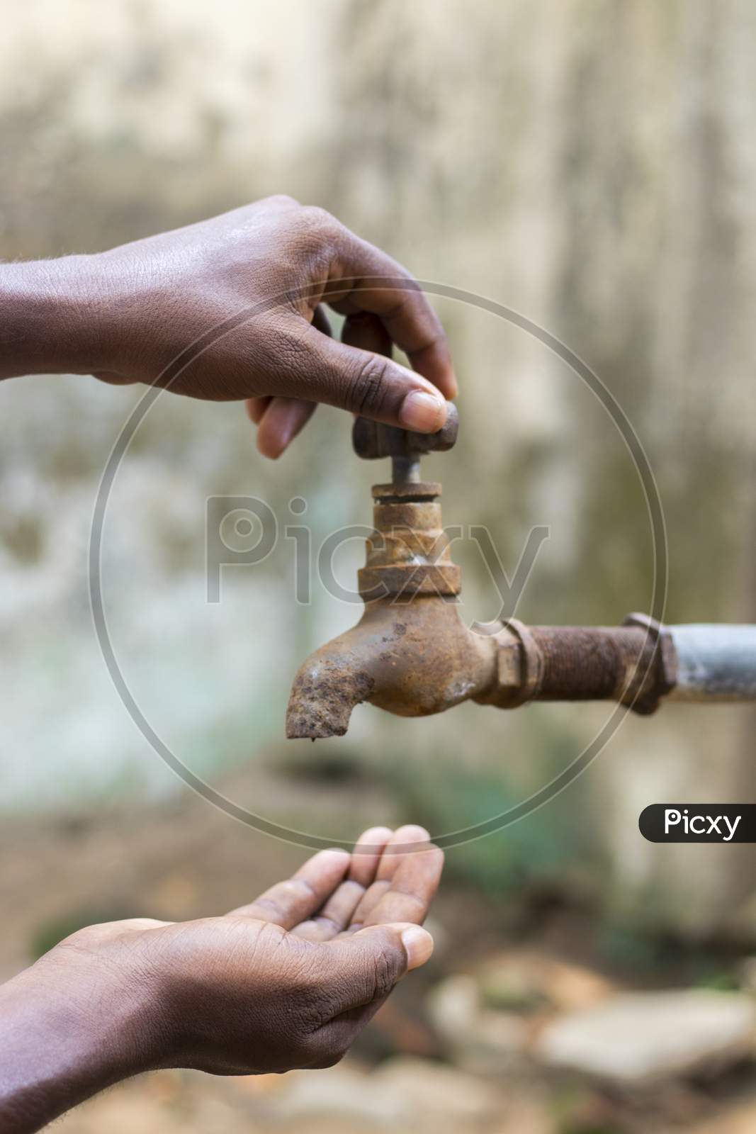 water crisis is a serious threat to India and worldwide,a man holding his hand under the tap for water