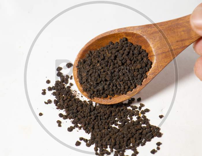 Dried Tea Leaves powder on Spoon With White Background