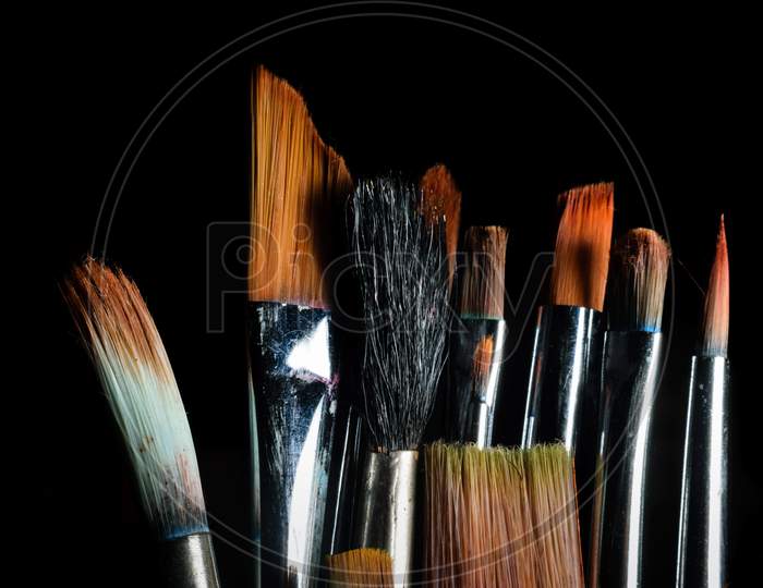 Paint Brushes Of Different Size Are Kept Side By Side In A Dark Background