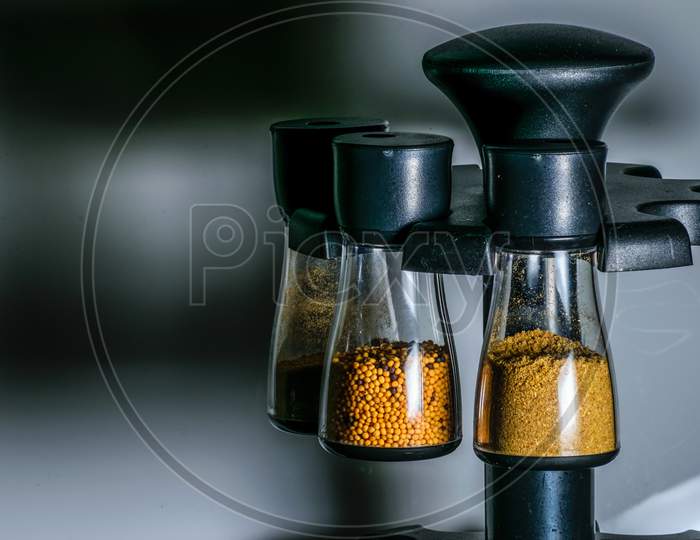 Transparent Containers Containing Mustard Seeds, Coriander Powder And Cumin Powder