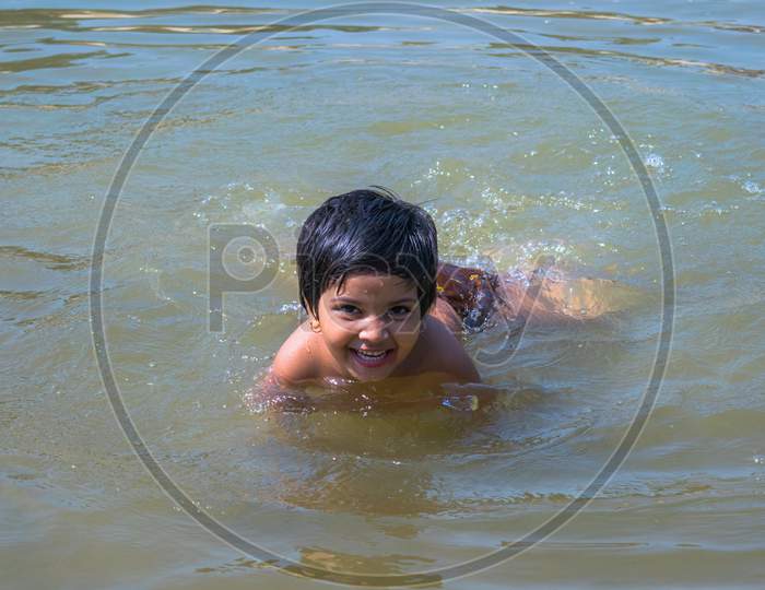 A cute girl swimming in lake in village
