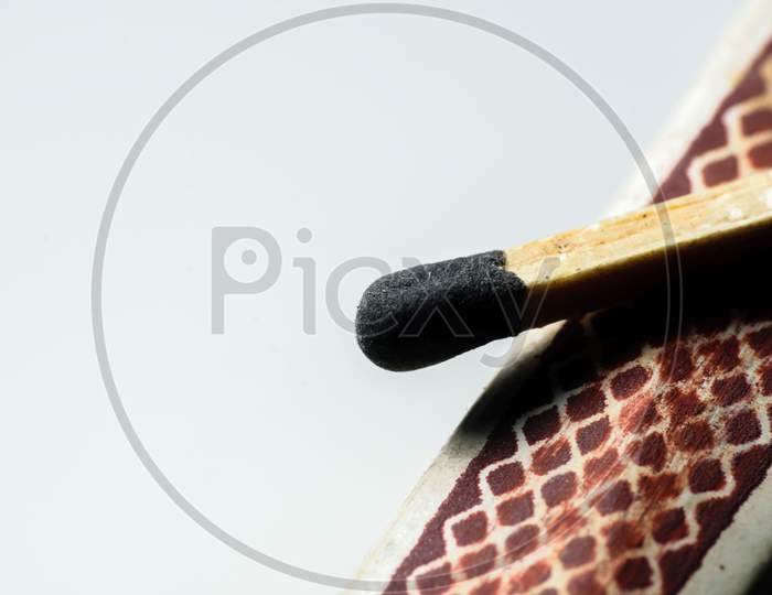 Isolated Match Stick Kept Over The Edge Of A Matchbox In A White Background. Space For Text In Left