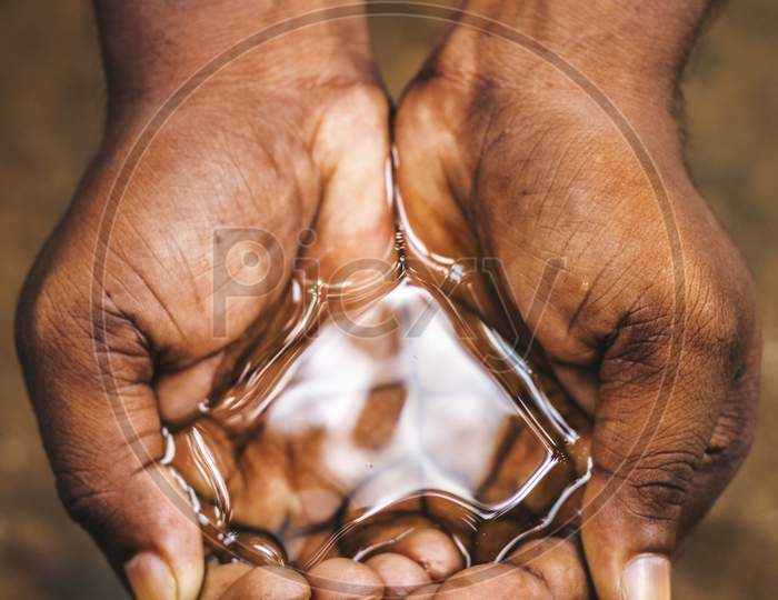 a man holding water with his hand,water crisis in India and worldwide