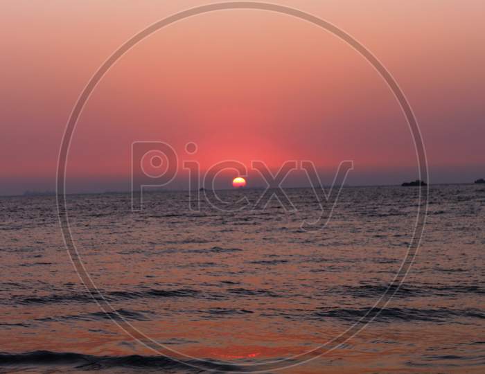 view of the pinkish sky during sunset at Miramar beach, Goa