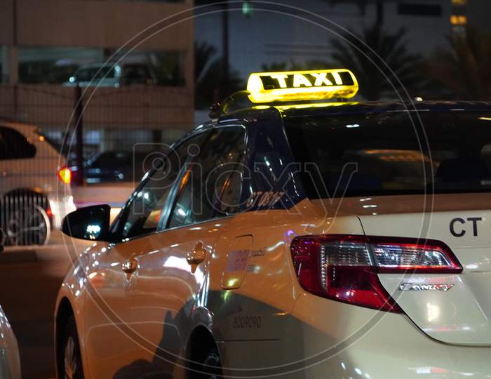 Dubai Uae - November 2019: Dubai Public Taxi Is Parked In A Parking Lot At Night. Taxi In The City Of Dubai - Dubai Has An Extensive Taxi System Rta.