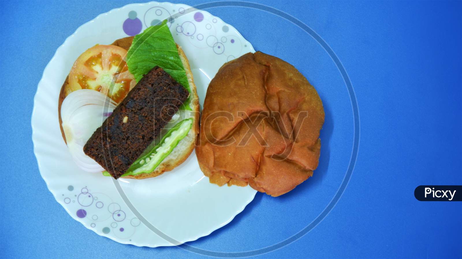 stuffed big burger on white plate and blue background