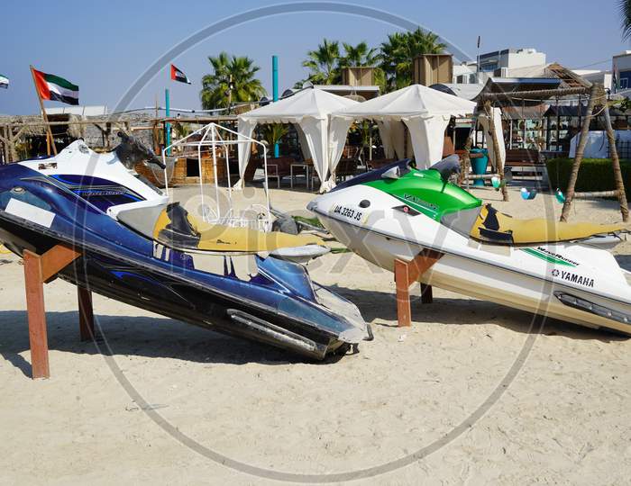 Two Colorful Jet Ski Parked On The Beach Of Holiday Season. Old Jet Skis On The Beach On Wooden Trailer. Blue And White Jet Ski - Dubai Uae January 2020