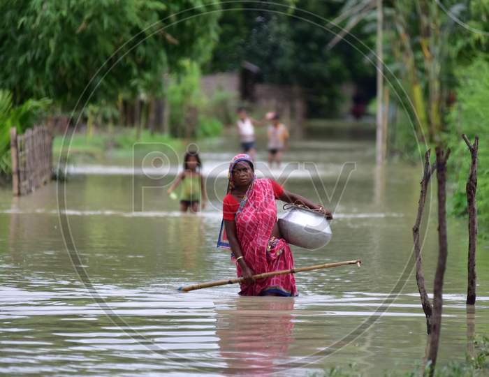 A Woman Wades Through The Floodwaters Following Heavy Rainfall At Bhurbandha Village In Nagaon District Of Assam On June 27,2020.