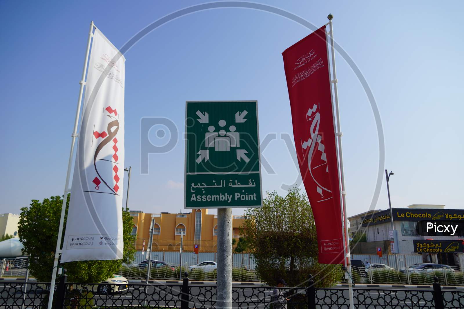 Dubai Uae - November 2019: Emergency Assembly Point Information Sign In White Paint On Green Background Fixed To A Pole To Direct People Where To Go In Case Of An Emergency.