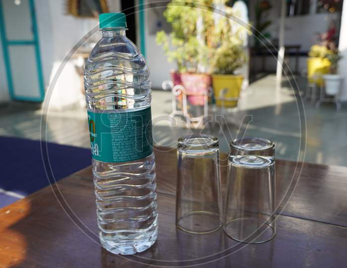 Mineral Water Of Bisleri In A Single Use Disposable Plastic Bottle Is Placed On Dining Table With 2 Glasses. : Udaipur India - March 2020