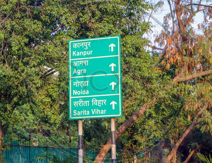 "New Delhi /India-21.06.2020: Sign Board In Green Showing Distance Of Town Kanpur ,Agra ,Noida And Sarita Viahr Texture In  English and Hindi   White Color"