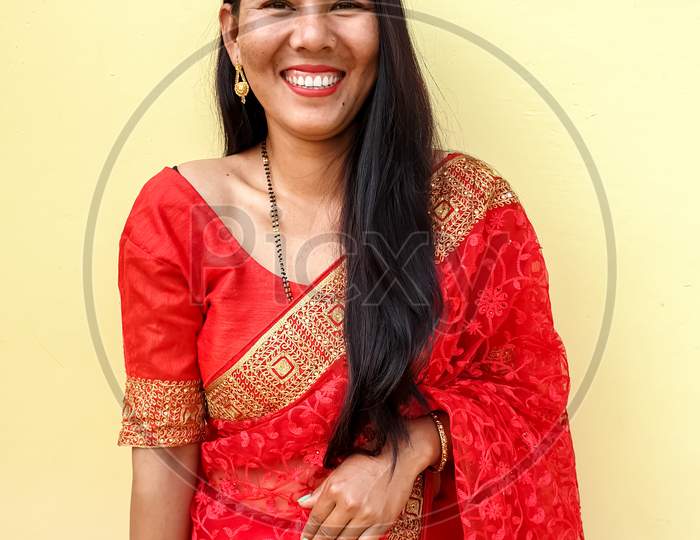 Portrait of beautiful Asian girl smiling pose with wearing red color saree