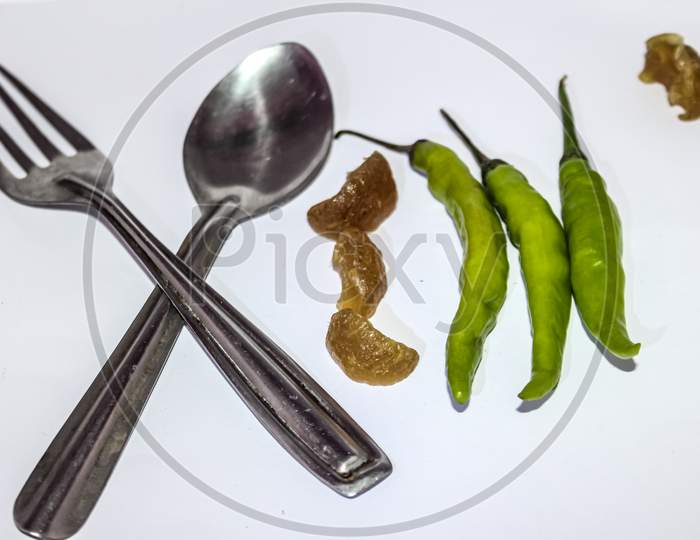 Spoon and forks with green chillies