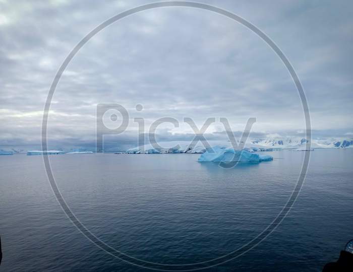 Snow covered mountain and floating iceberg in Antarctica