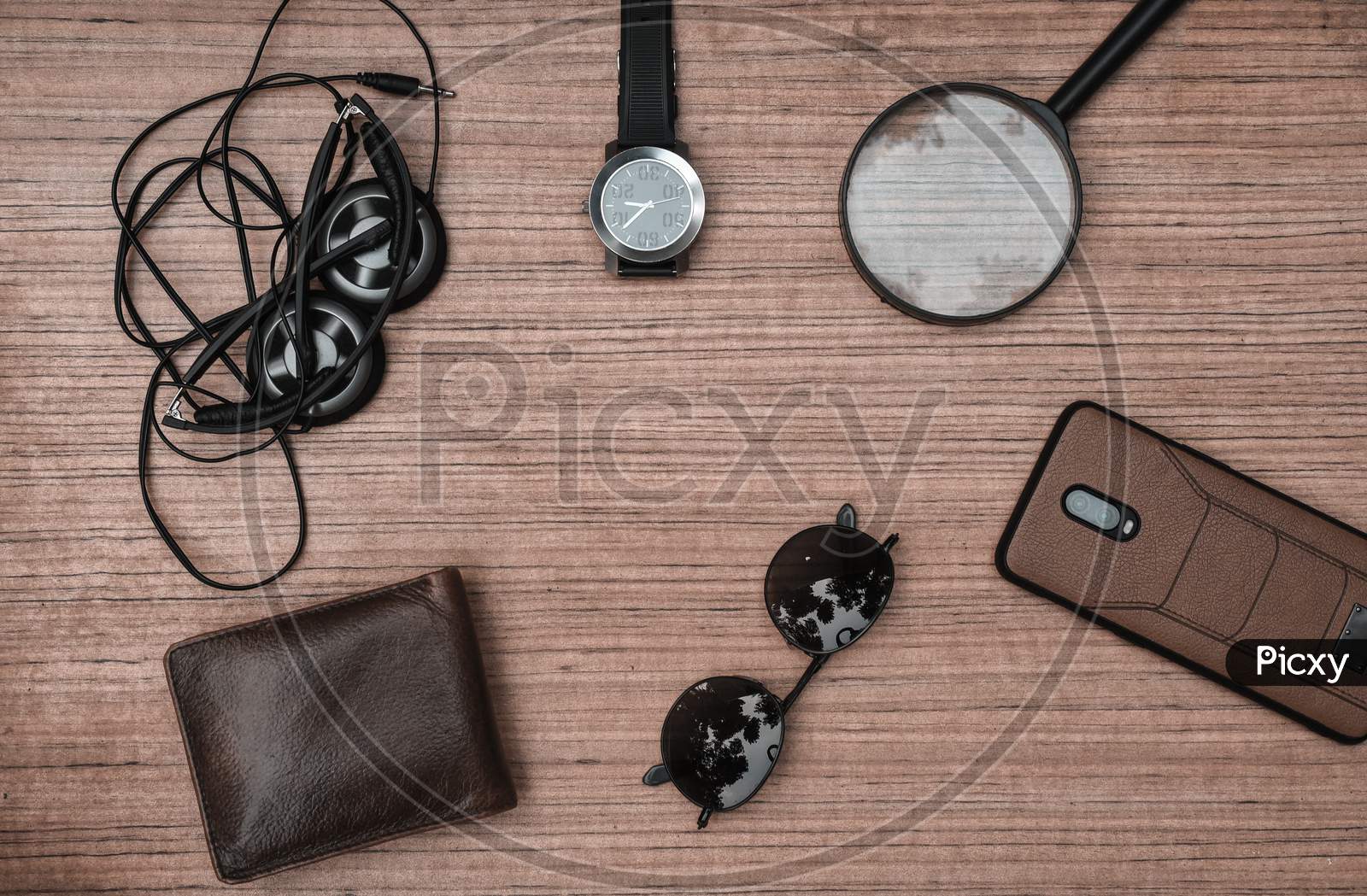 Top view accessories to travel with man clothing concept.telephone,bow tie,passport on wooden background.air plane,sunglasses,headphone,tree on wood table.flat lay.copy space.music listening.