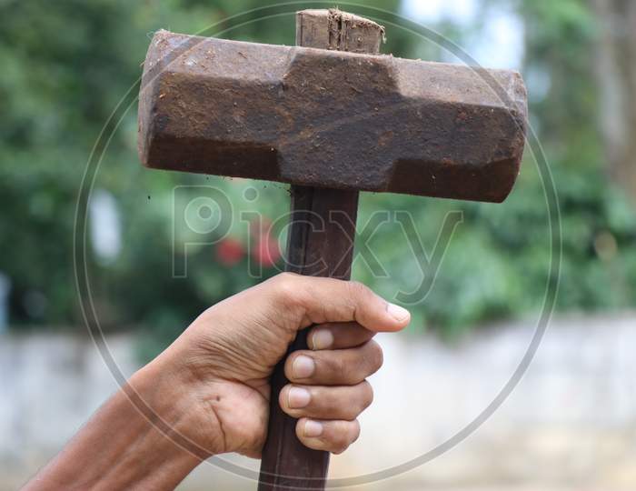 Old And Rusty Hammer Held In Hand Which Is Having Wooden Handle