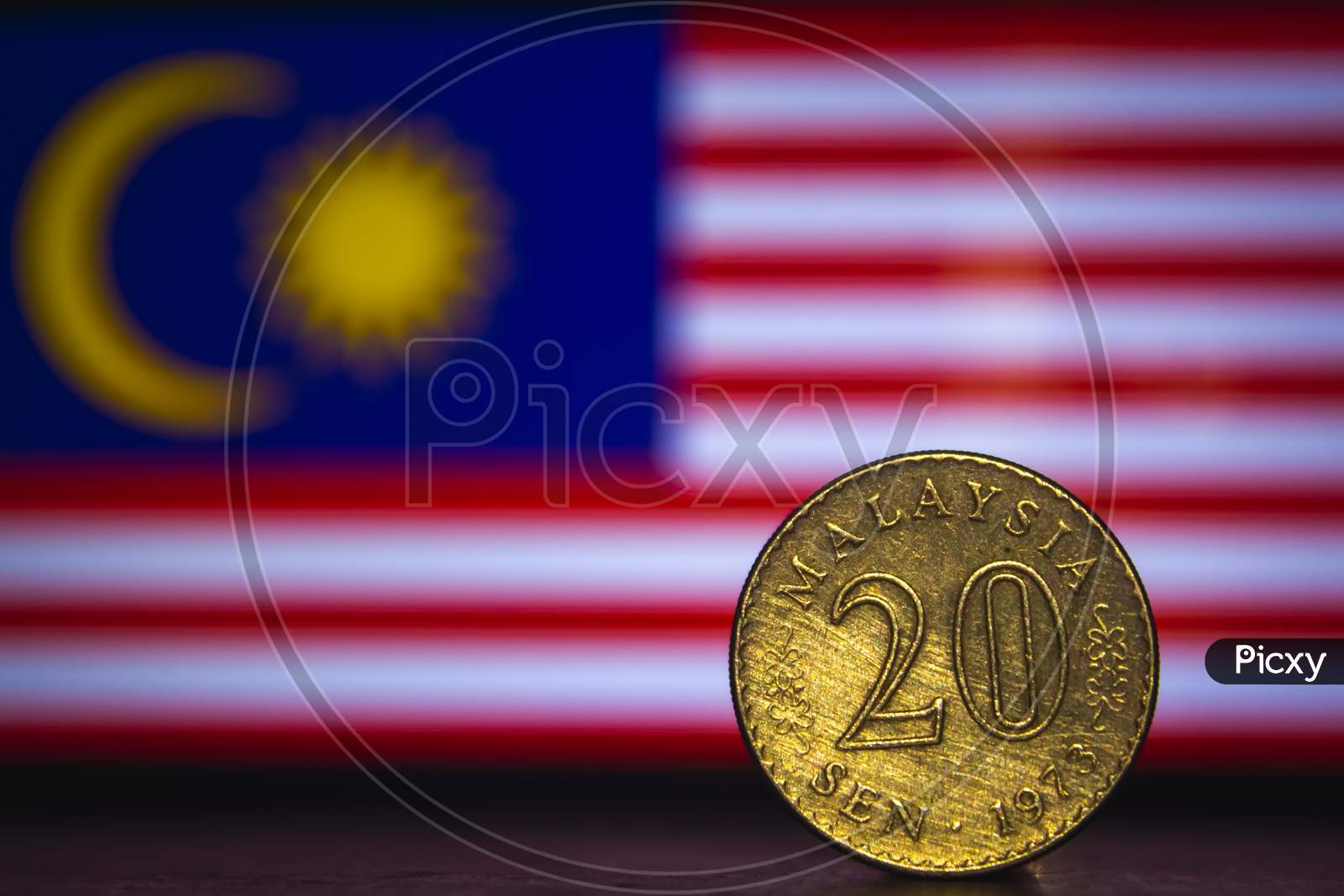 Malaysian Coin - Malaysia 20 Sen 1973 Coin Isolated On Malaysia Flag Background. Malaysian Currency Twenty Sen Coin With Space For Text Copy.