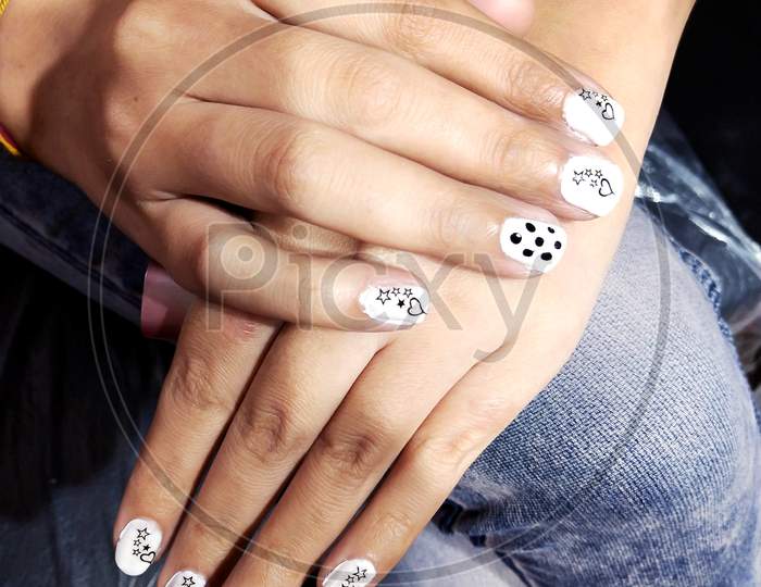 High Angle Shot Of Female Hands With A White Manicure With Black Drawings