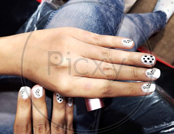High Angle Shot Of Female Hands With A White Manicure With Black Drawings