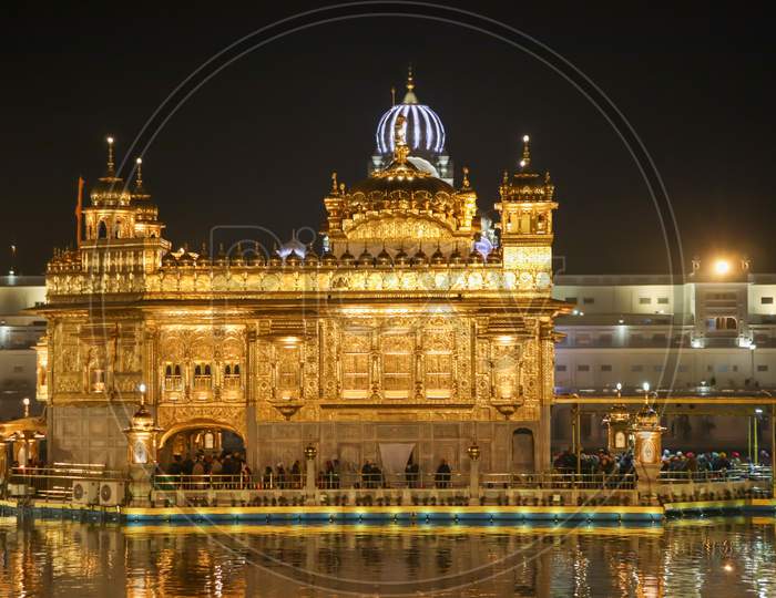 Golden Temple With Reflection In The Water At Night
